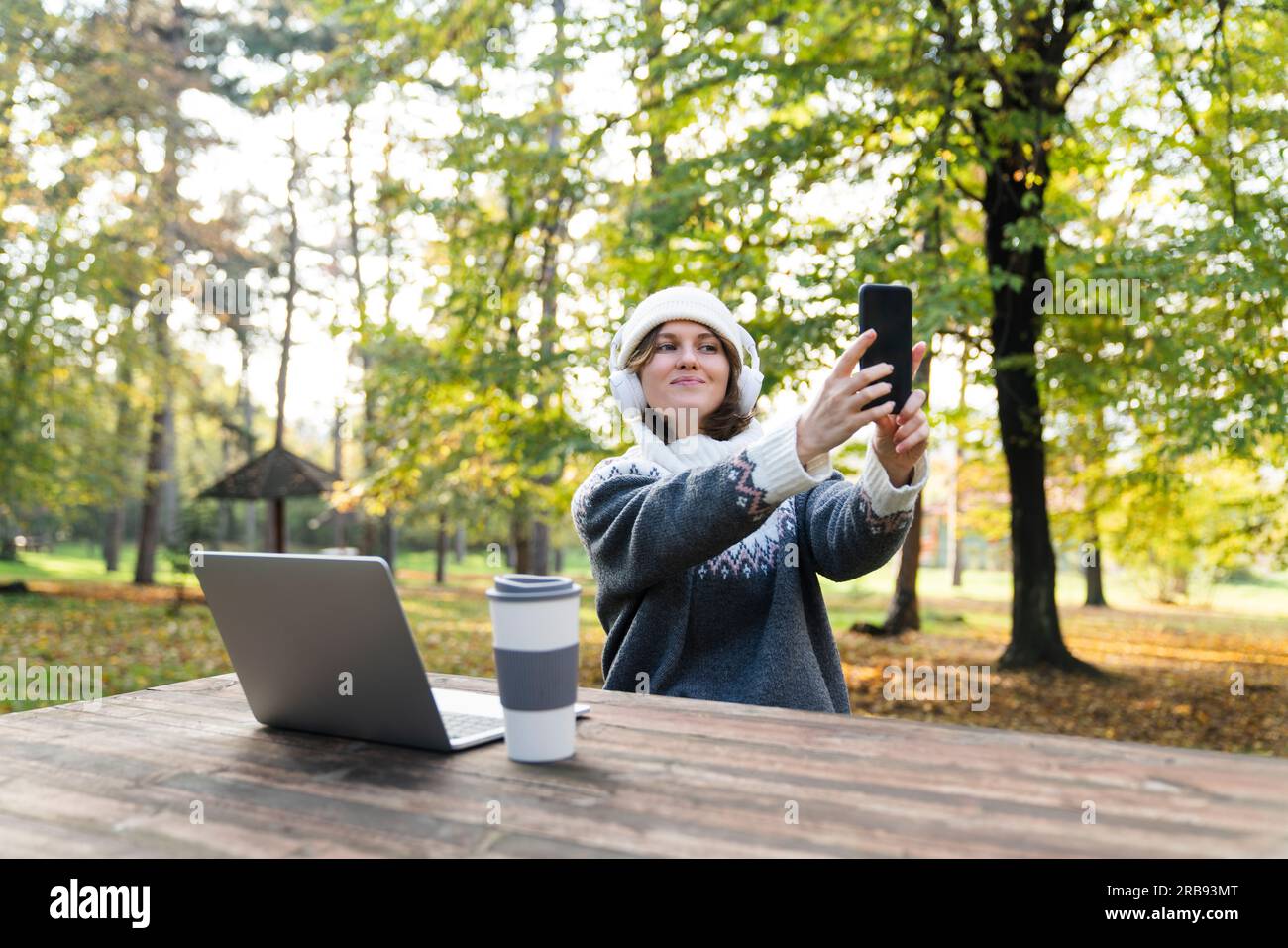 Travailleur indépendant travaillant sur ordinateur portable dans le parc d'automne. Banque D'Images