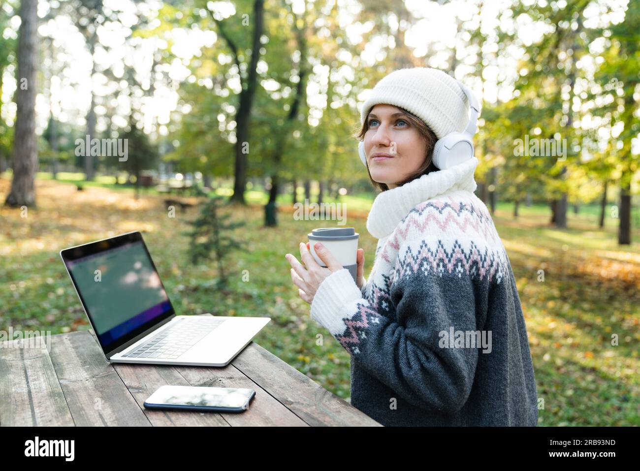 Travailleur indépendant travaillant sur ordinateur portable dans le parc d'automne. Banque D'Images