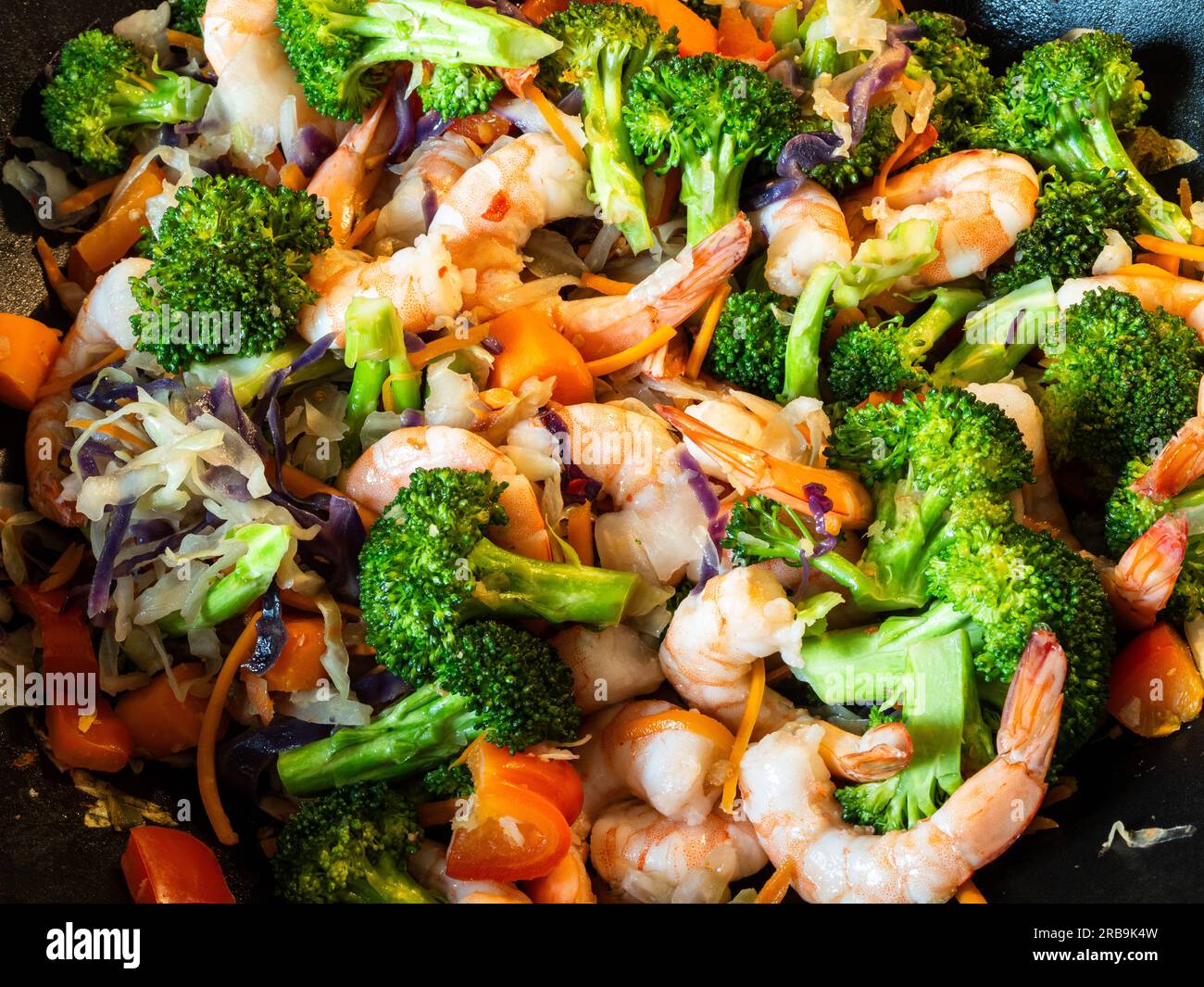 Dans un gros plan captivant, un plat de fruits de mer sautés, coloré et sain occupe le devant de la scène. La combinaison délicieuse de succulent SH Banque D'Images