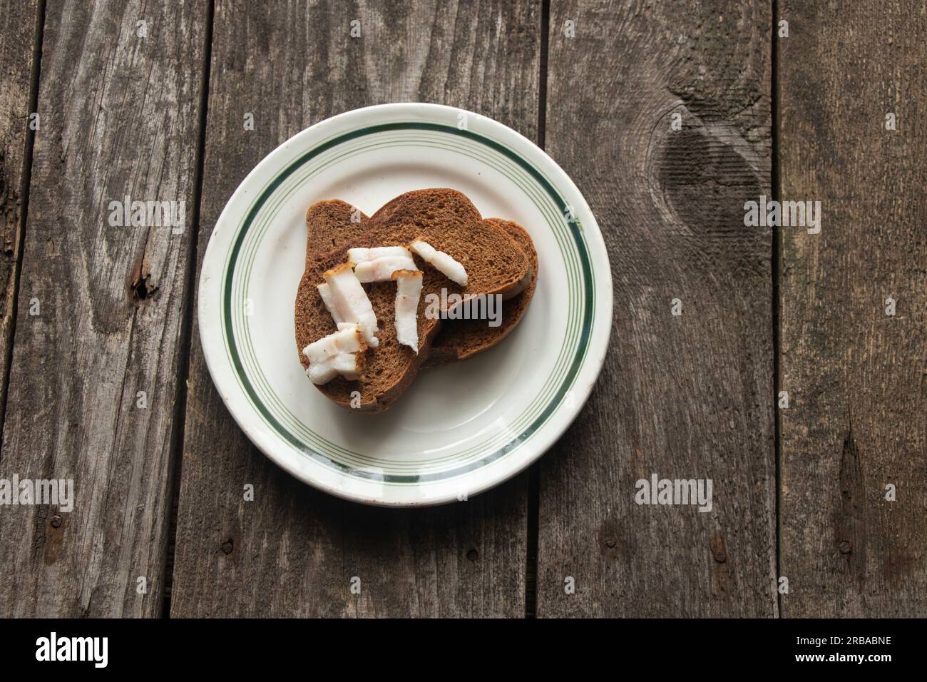 tranche de pain noire avec bacon sur une assiette sur une table en bois pour le déjeuner Banque D'Images tranche de pain noire avec bacon sur une assiette sur une table en bois pour le déjeuner Banque D'Images