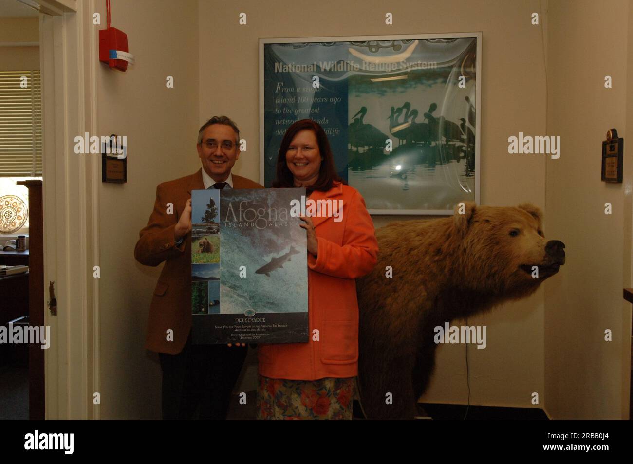 Dre Pearce, conseillère principale auprès du secrétaire aux Affaires de l’Alaska, et collègue avec affiche de la Rocky Mountain Elk Foundation remerciant Pearce pour son travail au nom du projet Perenosa Bay sur l’île d’Afognak, en Alaska. Afognak, dont les populations de poissons et d’animaux sauvages de la rive nord ont été endommagées par le déversement de pétrole de l’Exxon Valdez en 1989, a été au centre des efforts de conservation et de rétablissement entrepris par les États-Unis Fish and Wildlife Service en partenariat avec l'État de l'Alaska et des organisations à but non lucratif. Banque D'Images