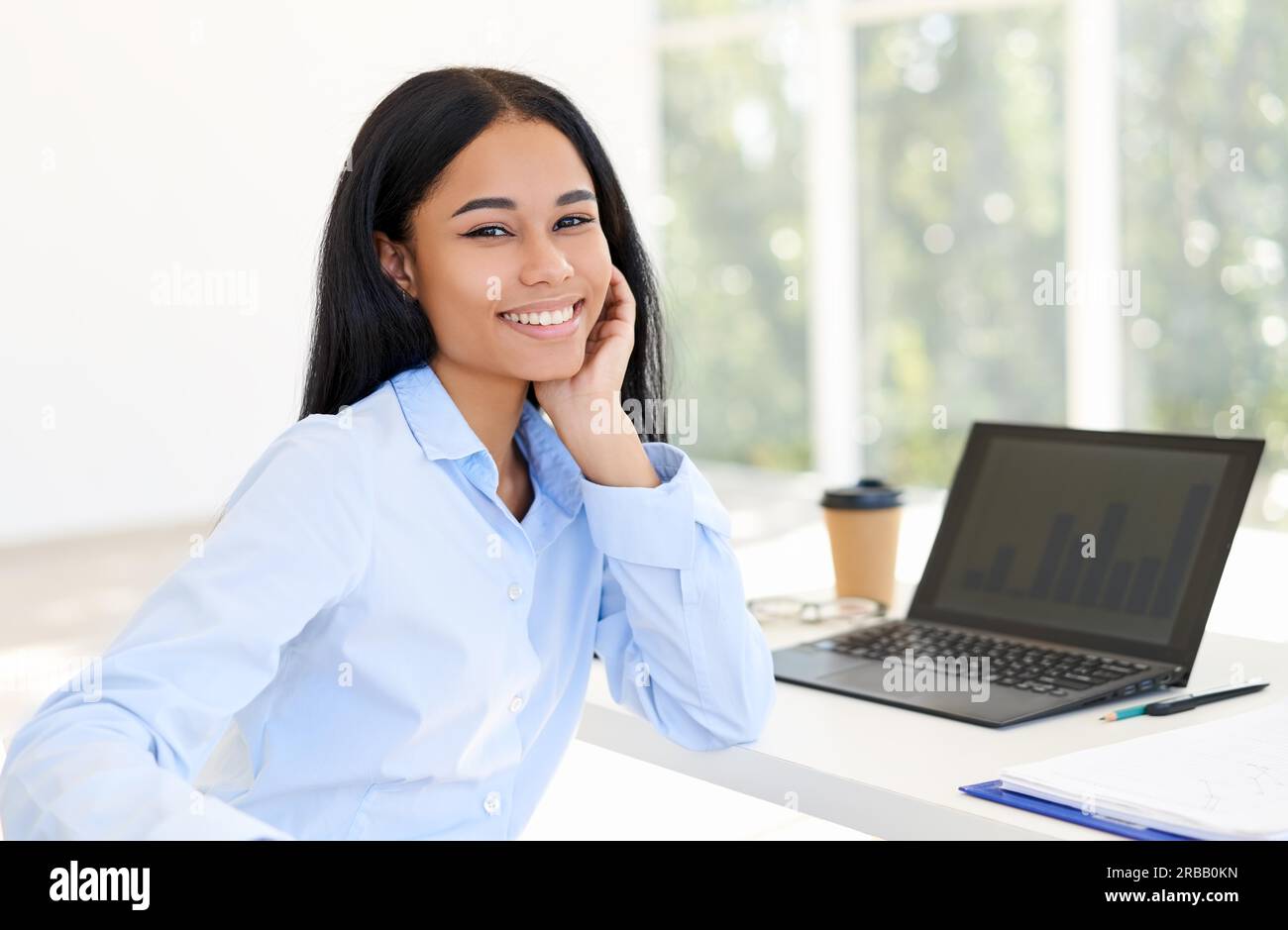 Bonne femme d'affaires noire posant à son bureau dans un bureau moderne lumineux. Concept de réussite d'affaires Banque D'Images