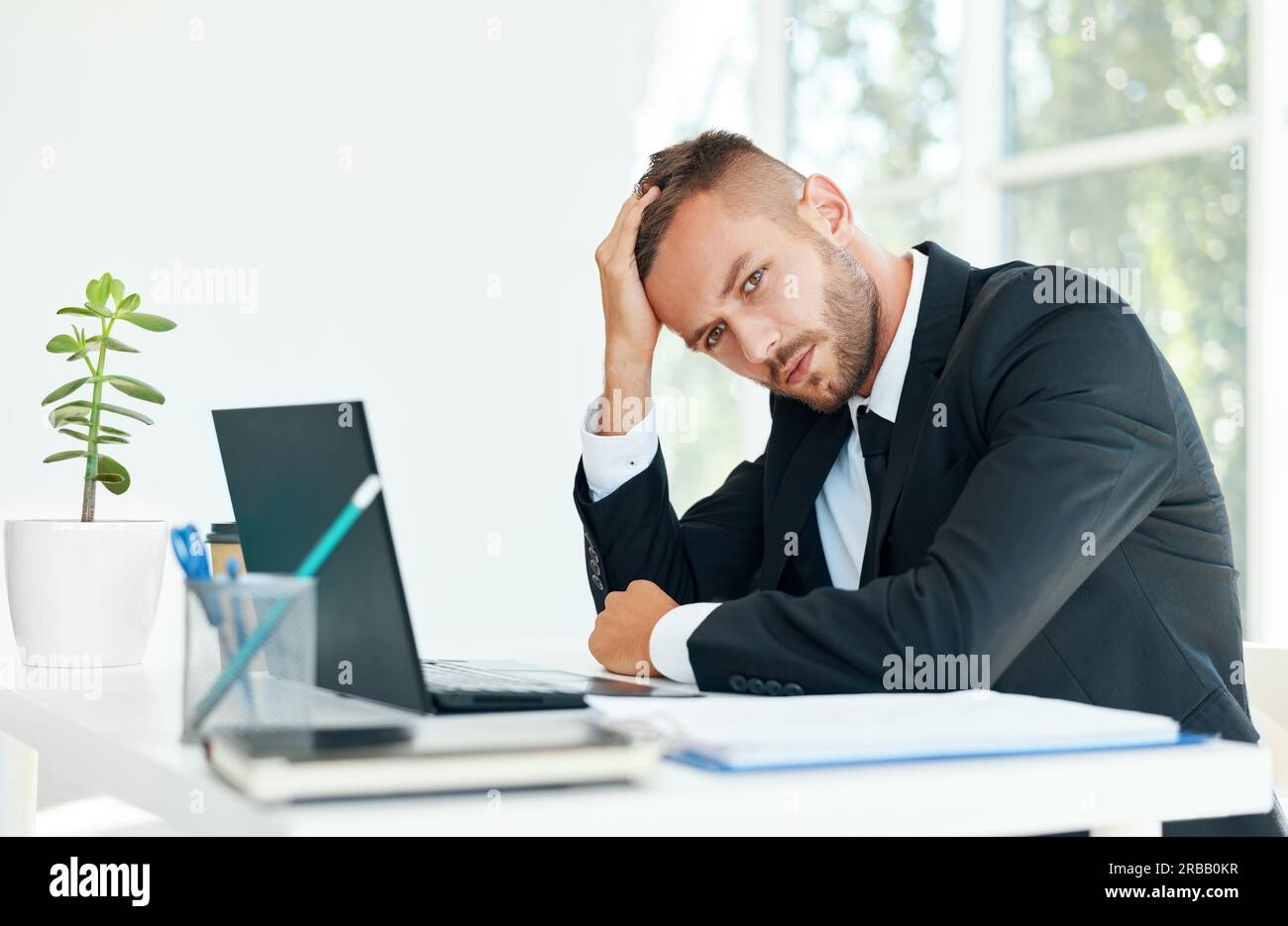 Homme d'affaires stressé et fatigué assis à la réception dans un bureau créatif. L'homme souffre de maux de tête, de problèmes concept Banque D'Images