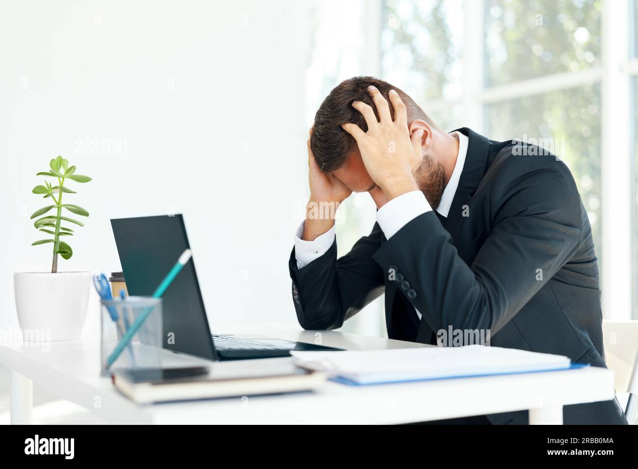 Homme d'affaires stressé et fatigué assis à la réception dans un bureau créatif. L'homme souffre de maux de tête, de problèmes concept Banque D'Images