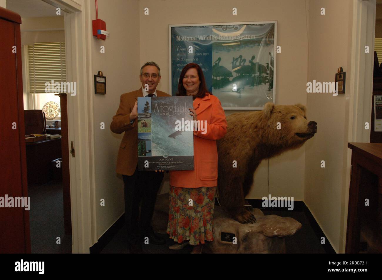 Dre Pearce, conseillère principale auprès du secrétaire aux Affaires de l’Alaska, et collègue avec affiche de la Rocky Mountain Elk Foundation remerciant Pearce pour son travail au nom du projet Perenosa Bay sur l’île d’Afognak, en Alaska. Afognak, dont les populations de poissons et d’animaux sauvages de la rive nord ont été endommagées par le déversement de pétrole de l’Exxon Valdez en 1989, a été au centre des efforts de conservation et de rétablissement entrepris par les États-Unis Fish and Wildlife Service en partenariat avec l'État de l'Alaska et des organisations à but non lucratif. Banque D'Images