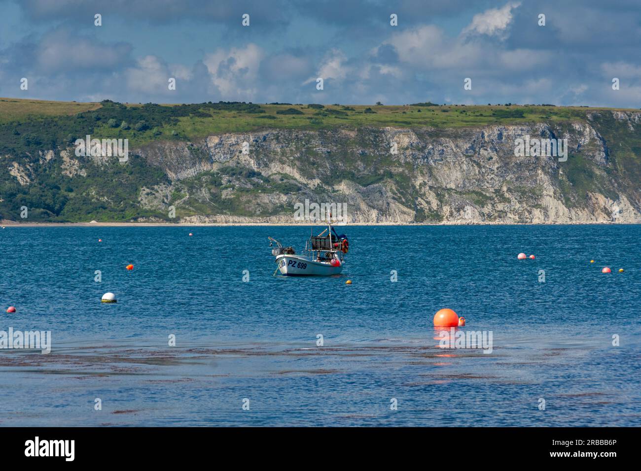 Swanage, Royaume-Uni - 21 juin 2023 : bateau de pêche dans la baie en face de Ballard Cliff. Banque D'Images