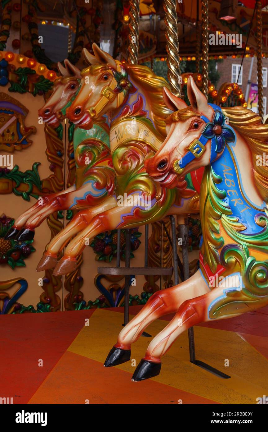 Gros plan de trois chevaux colorés dans un joyeux manège Banque D'Images