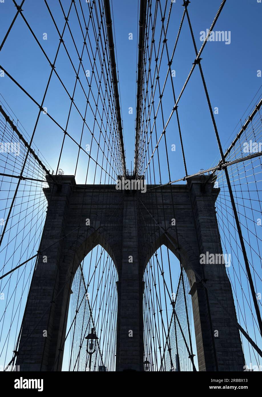 Câbles menant à une tour sur le pont de Brooklyn contre un ciel bleu Banque D'Images