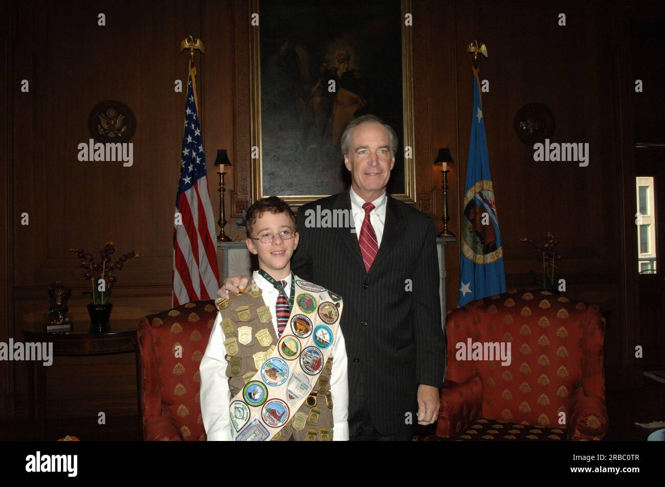 Le secrétaire Dirk Kempthorne reçoit la visite au main Interior du participant au programme des Junior Ranger du Service des parcs nationaux, qui a montré ses nombreux badges et patchs de Junior Ranger pour la secrétaire et directrice du Service des parcs nationaux Mary Bomar Banque D'Images