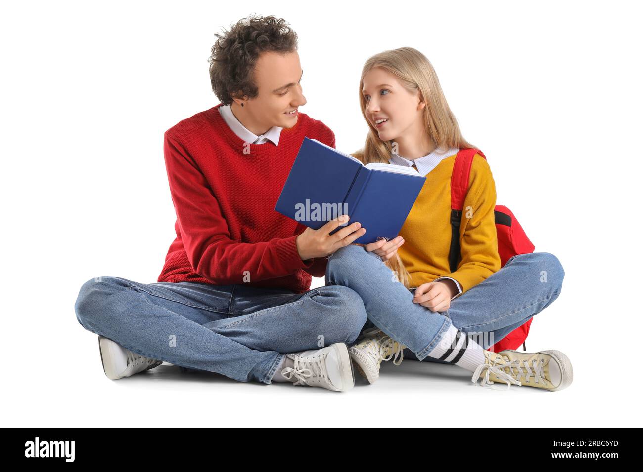 Couple adolescent lisant livre sur fond blanc Banque D'Images