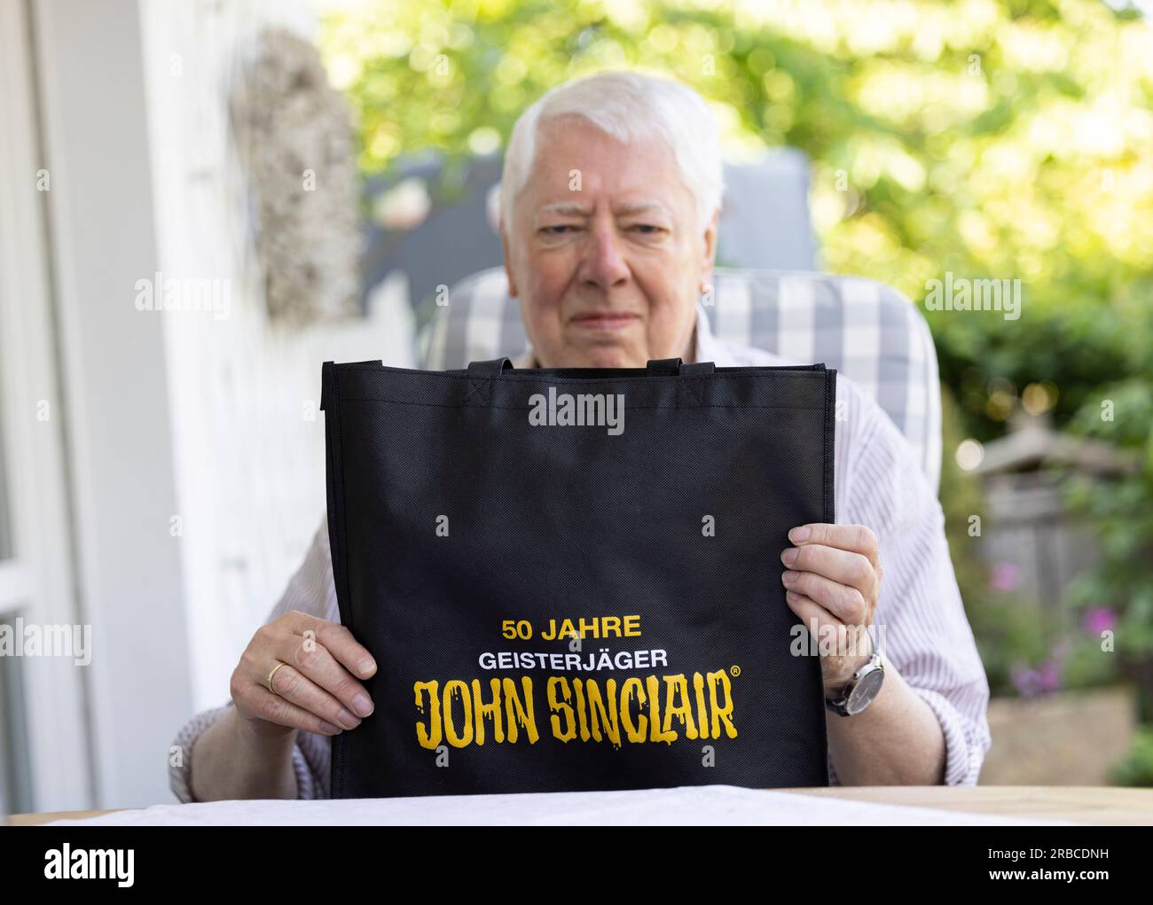 Bergisch Gladbach, Allemagne. 16 juin 2023. Helmut Rellergerd, auteur, donne une interview dans son jardin et montre un sac avec l'empreinte: "50 ans de chasseur de fantômes John Sinclair". Rellergerd, qui écrit sous le pseudonyme de Jason Dark depuis 50 ans, est l'auteur des romans John Sinclair. (À dpa : '50 ans de John Sinclair - son auteur a horreur sur son esprit') crédit : Thomas Banneyer/dpa/Alamy Live News Banque D'Images