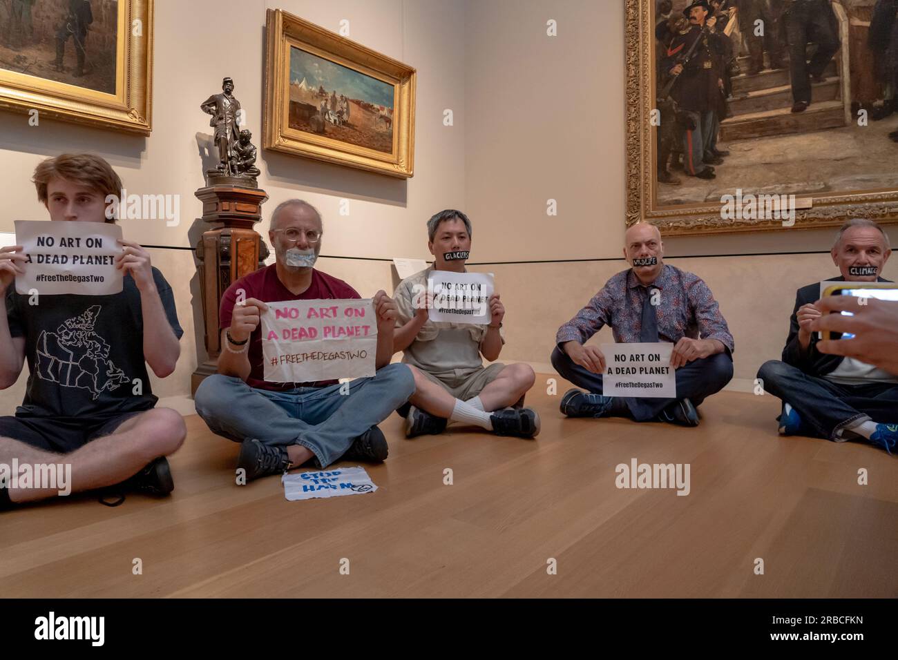 NEW YORK, NEW YORK - JUILLET 08 : les membres d'extinction Rebellion NYC et se lèvent et résistent avec des bandes de bande sur la bouche, sur lesquelles ils avaient écrit des mots tels que «Terre», Les glaciers et la famine, ainsi que les panneaux indiquant « PAS D'ART SUR Une PLANÈTE MORTE », ont organisé une manifestation de solidarité appelant à abandonner les charges contre Joanna Smith et Tim Martin à la collection American Wing du Metropolitan Museum of Art le 8 juillet 2023 à New York. Joanna Smith et Tim Martin ont étalé de la peinture sur le cas d'une sculpture de Degas lors d'un acte de désobéissance civile à la National Gallery of Art de Washington, DC. Crédit : Ron Adar/Ala Banque D'Images