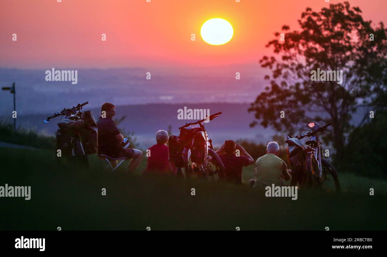 Uttenweiler, Allemagne. 09 juillet 2023. Les cyclistes regardent le lever du soleil le matin. Des températures supérieures à 30 degrés sont prévues pour aujourd'hui. Crédit : Thomas Warnack/dpa/Alamy Live News Banque D'Images