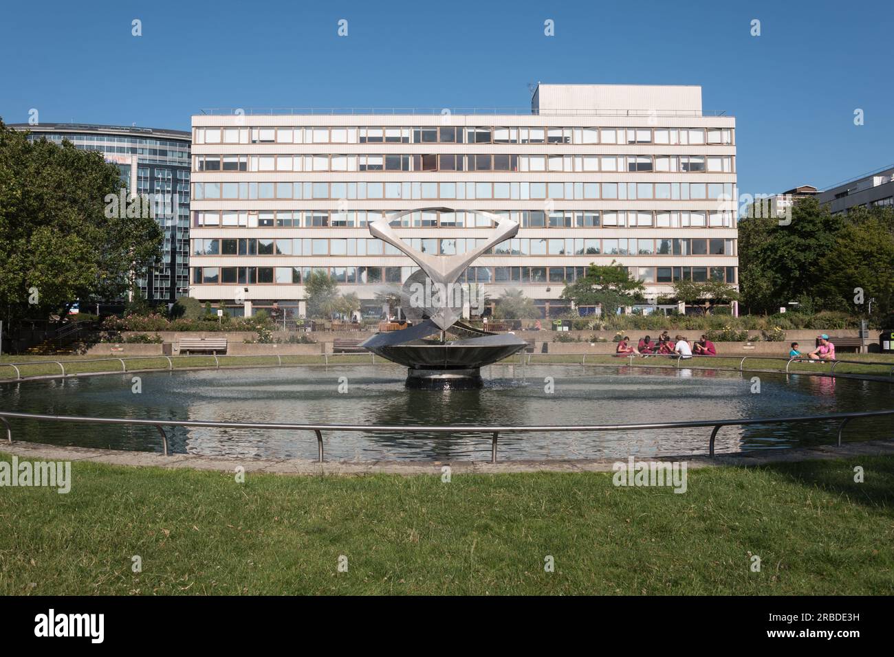 Le personnel médical se détend à côté de Naum Gabo's Revolving torsion Fountain dans St Thomas' Hospital Courtyard, Londres, SE1, Angleterre, Royaume-Uni Banque D'Images