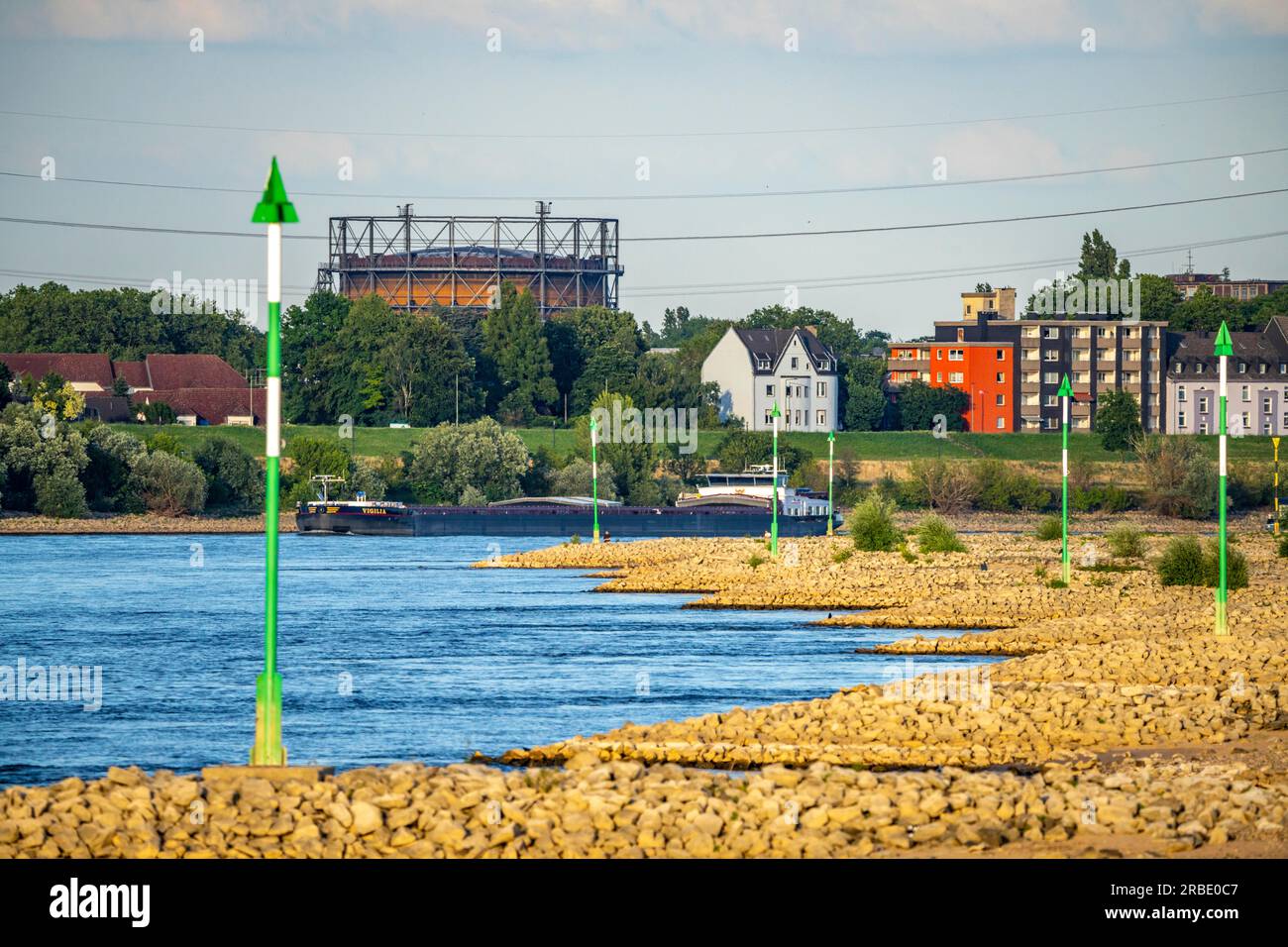 Navire de charge en eaux basses sur le Rhin près de Duisburg-Homberg, vue de Duisburg-Laar, maisons sur Deichstraße, gazomètre de ArcelorMittal Hochfeld GmbH Sta Banque D'Images