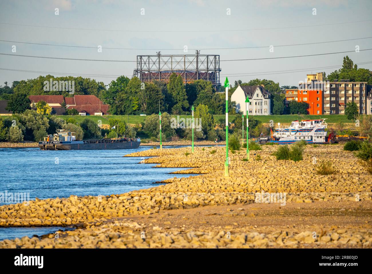 Navire de charge en eaux basses sur le Rhin près de Duisburg-Homberg, vue de Duisburg-Laar, maisons sur Deichstraße, gazomètre de ArcelorMittal Hochfeld GmbH Sta Banque D'Images