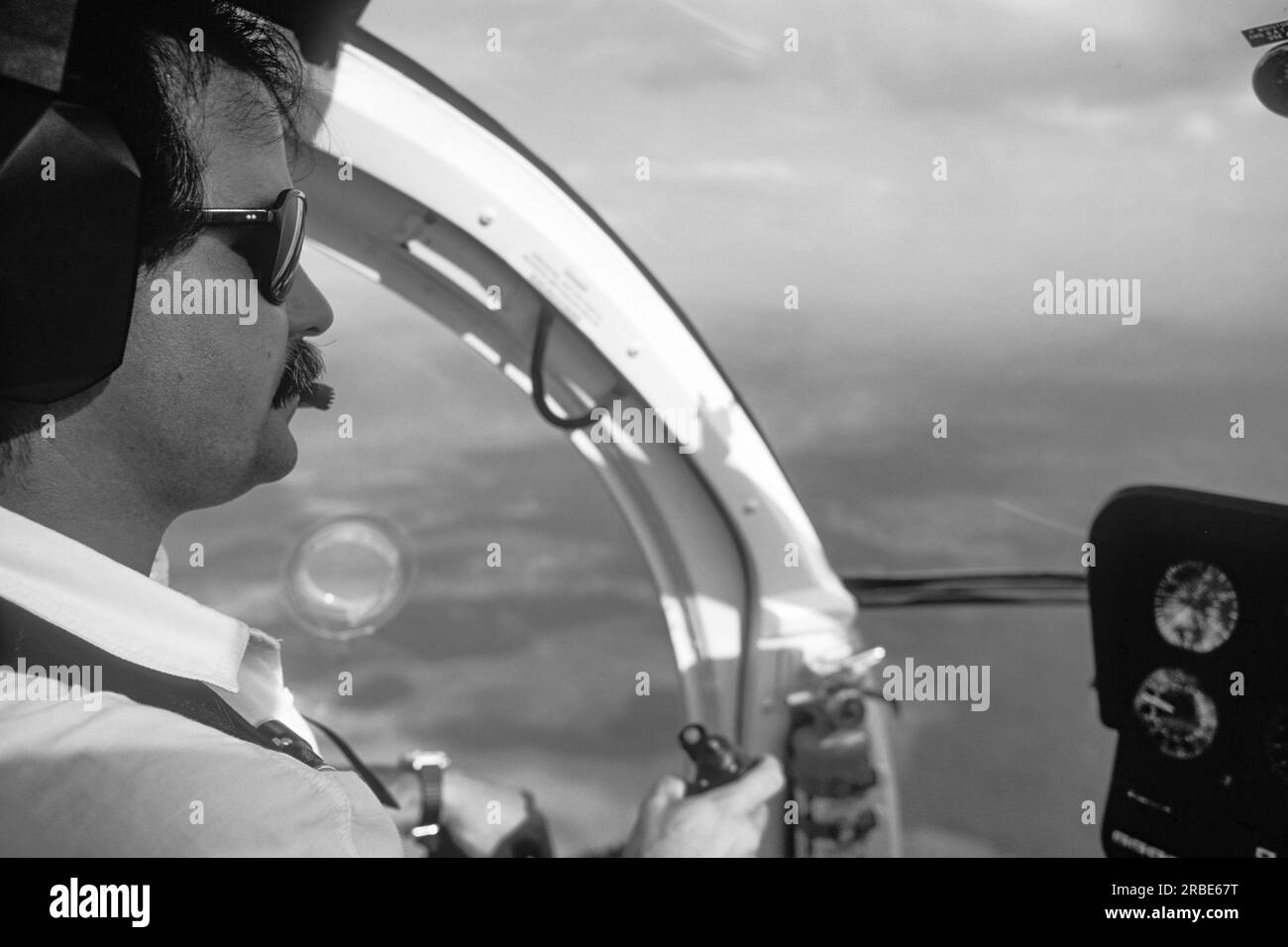 Homme pilote dans le cockpit d'un hélicoptère survolant une forêt tropicale, état d'Amazonas, Venezuela Banque D'Images