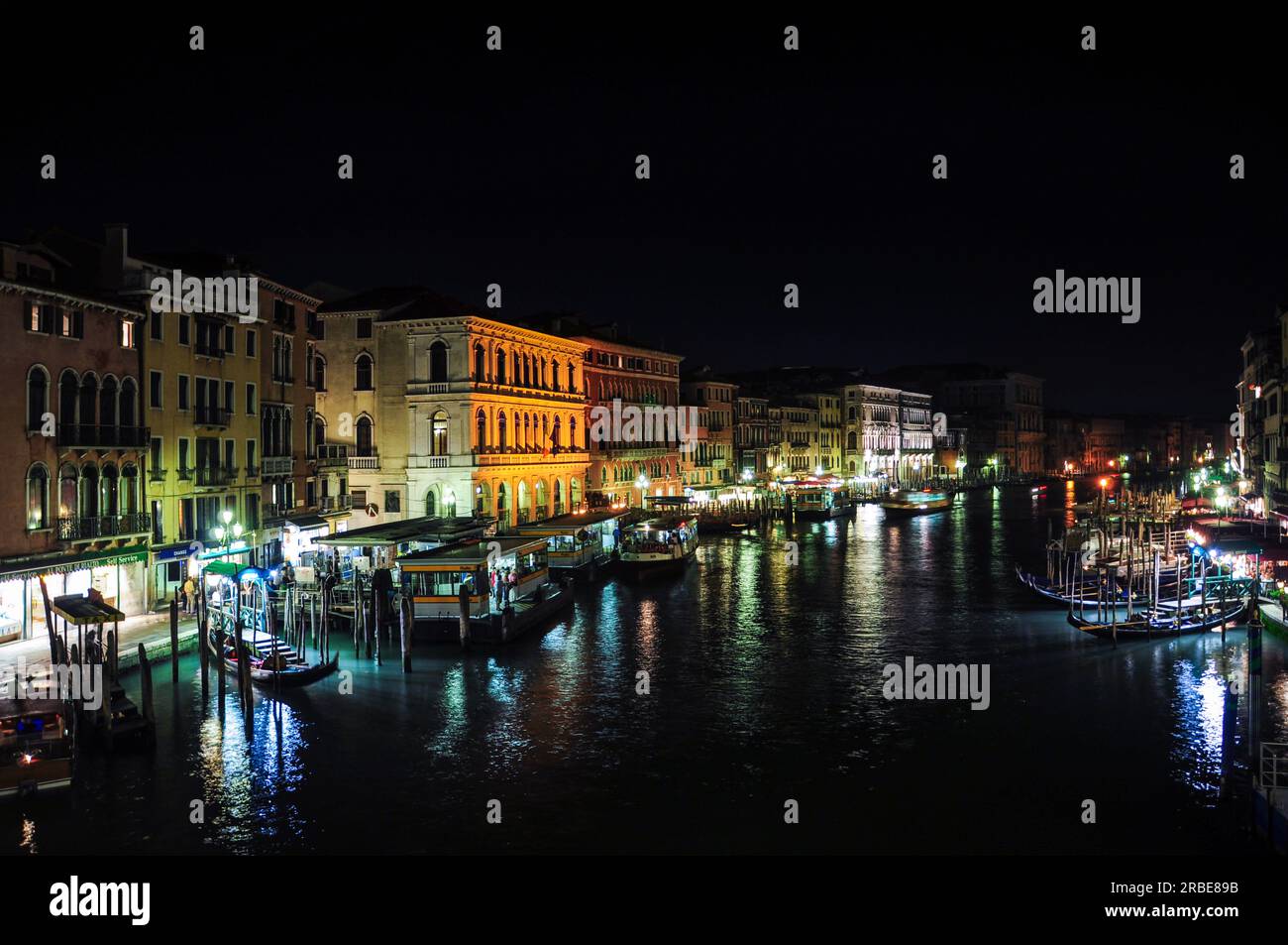 Vue nocturne sur le Grand Canal de Venise, avec de nombreuses gondoles et bateaux amarrés sur les rives de la rivière Banque D'Images