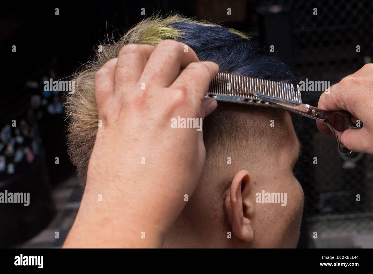 coupe de cheveux masculine dans un salon de coiffure en gros plan, client  se faisant couper les cheveux par un coiffeur avec un peigne et des ciseaux  11648227 Photo de stock chez Vecteezy