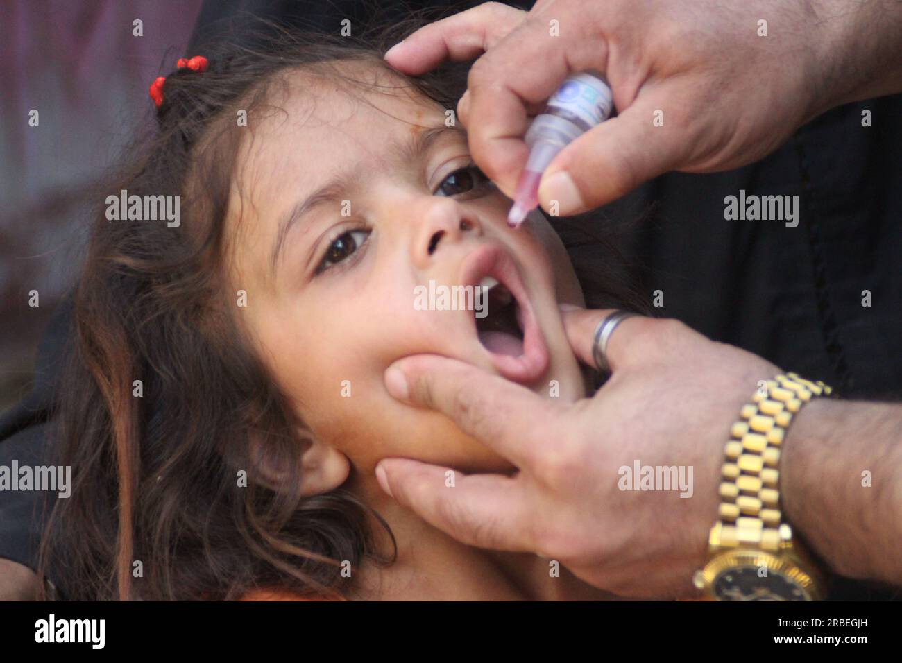 (230709) -- NANGARHAR, 9 juillet 2023 (Xinhua) -- Un agent de santé donne une dose de vaccin contre la poliomyélite à un enfant lors d'une campagne de lutte contre la poliomyélite dans la province de Nangarhar, Afghanistan, le 9 juillet 2023. Les autorités sanitaires afghanes ont lancé samedi une campagne de lutte contre la poliomyélite dans les provinces de Nangarhar, Laghman, Kunar et Nuristan, dans l'est de l'Afghanistan. (Photo de Aimal Zahir/Xinhua) Banque D'Images
