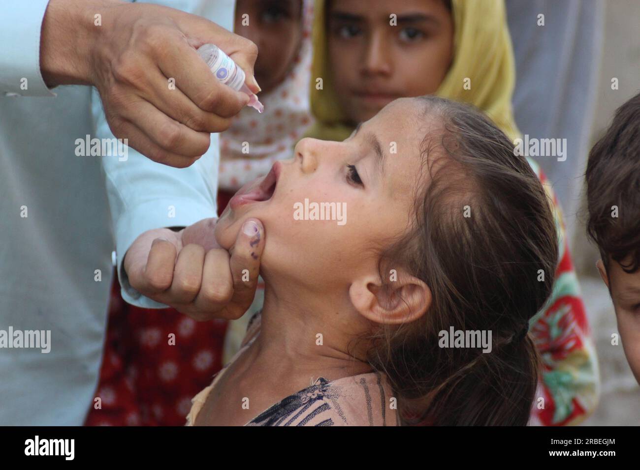 (230709) -- NANGARHAR, 9 juillet 2023 (Xinhua) -- Un agent de santé donne une dose de vaccin contre la poliomyélite à un enfant lors d'une campagne de lutte contre la poliomyélite dans la province de Nangarhar, Afghanistan, le 9 juillet 2023. Les autorités sanitaires afghanes ont lancé samedi une campagne de lutte contre la poliomyélite dans les provinces de Nangarhar, Laghman, Kunar et Nuristan, dans l'est de l'Afghanistan. (Photo de Aimal Zahir/Xinhua) Banque D'Images