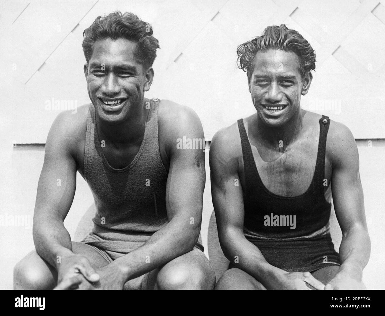 Long Beach, Californie : 15 juin 1924 les stars de natation hawaïennes Duke Kahanamoku (à gauche) et son jeune frère Sam lors d'une pause pendant les essais à la piscine olympique de long Beach pour les Jeux olympiques d'été de 1924. Duke a remporté la médaille d'or du 100 mètres freestyle aux Olympoics 1912 à Stockholm. Banque D'Images