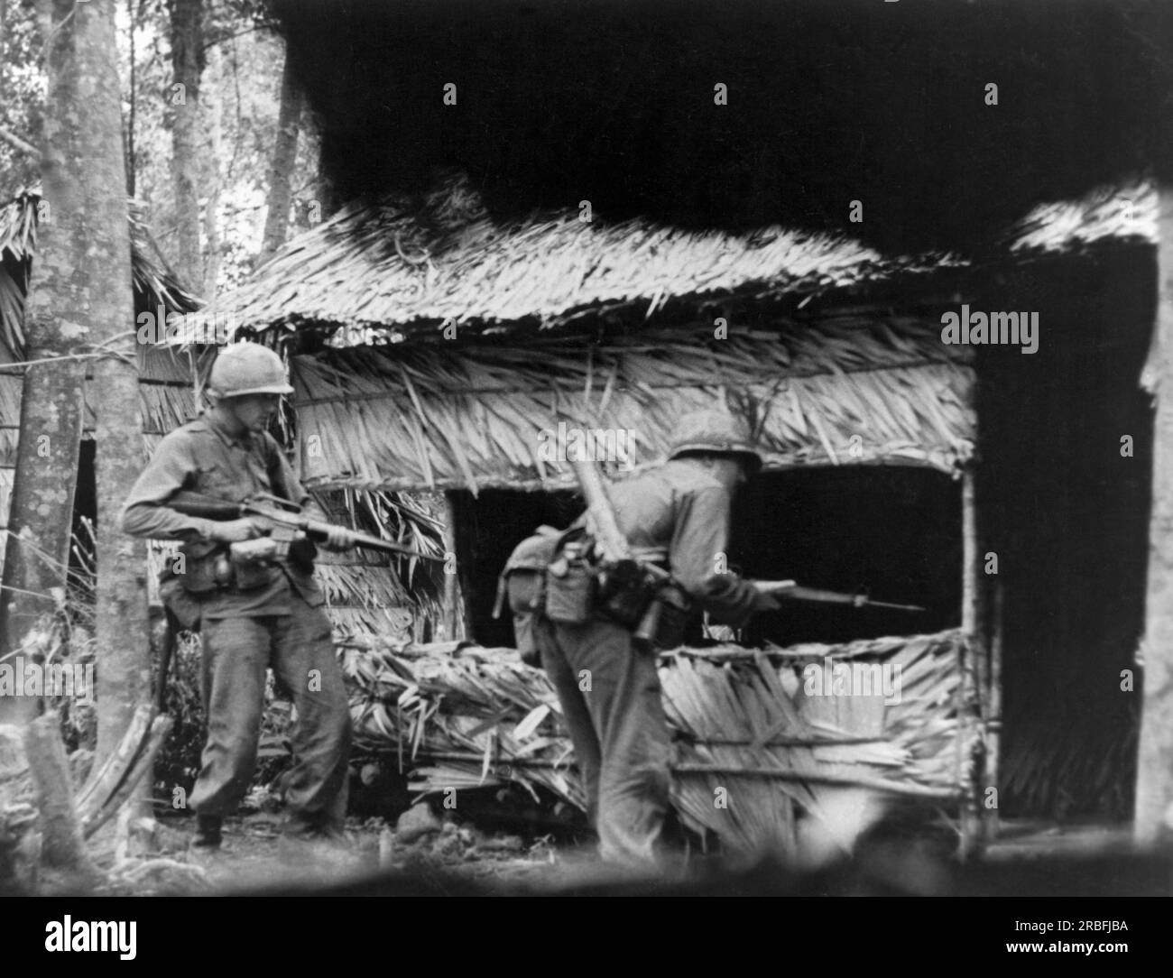 Tuy Hoa, Vietnam : août 1966 deux parachutistes de la 101st Airborne Division fouillent un camp de base ennemi pendant l'opération John Paul Jones. Banque D'Images