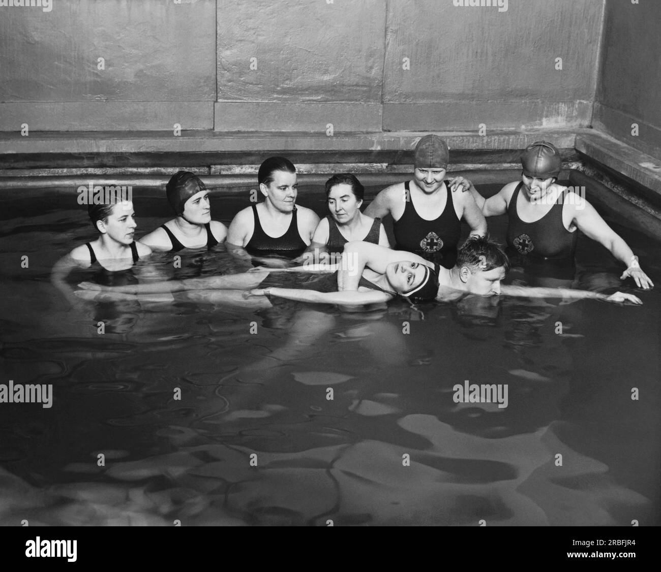 Chicago, Illinois : c. 1930 deux instructeurs de la Croix-Rouge américaine donnant un cours de sauvetage dans une piscine. Banque D'Images