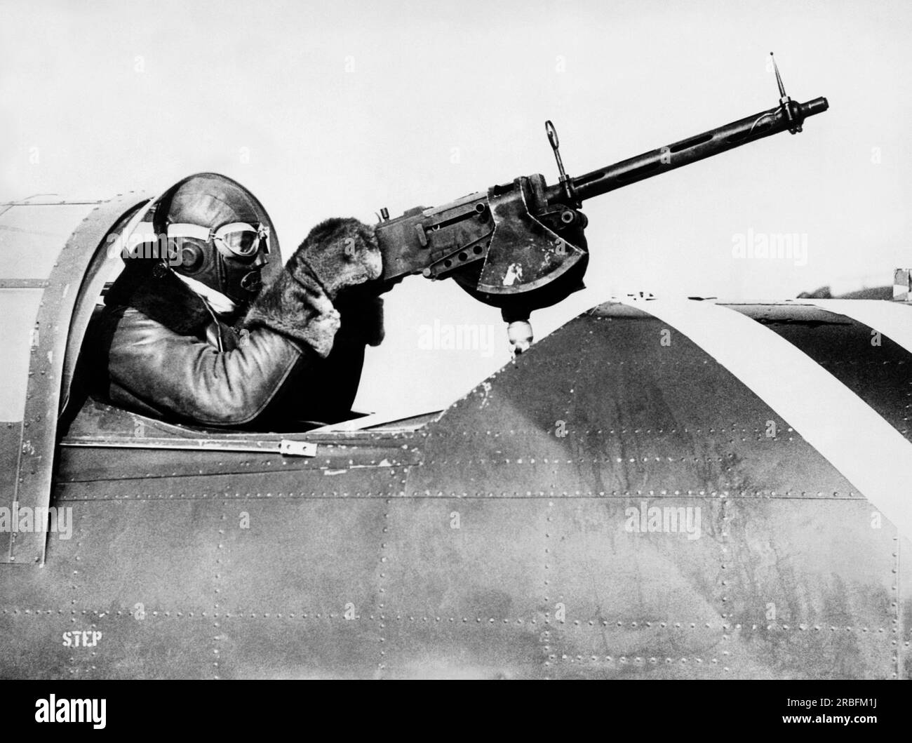 Hempstead, New York : c. 1933 Un Chilly Army Air Corp sargeant dans le cockpit d'artillerie d'un avion d'attaque pendant des manœuvres d'essai hivernales à Mitchell Field sur long Island. Il est habillé pour voler dans un cockpit ouvert par temps zéro. Banque D'Images