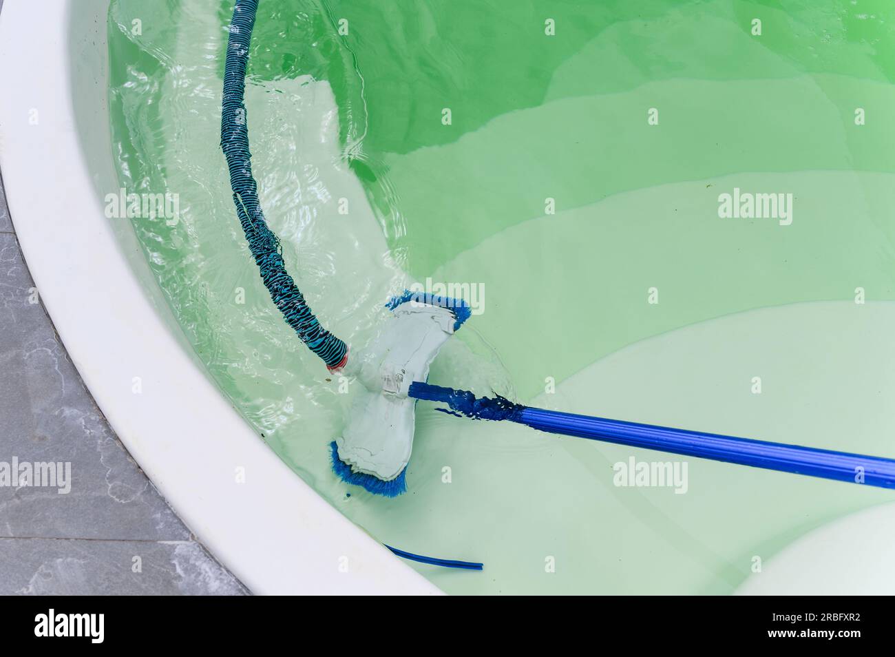 Nettoyage du fond de la piscine par aspirateur sous-marin. Vue d'en haut. Banque D'Images