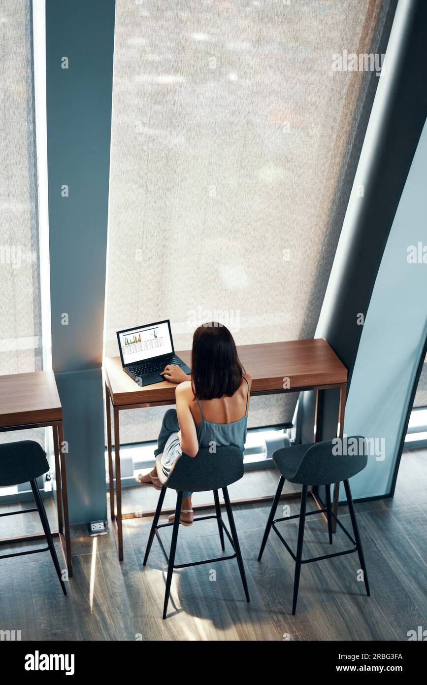 Vue de dessus de young Beautiful woman working on laptop in office moderne ou l'espace cafe Banque D'Images