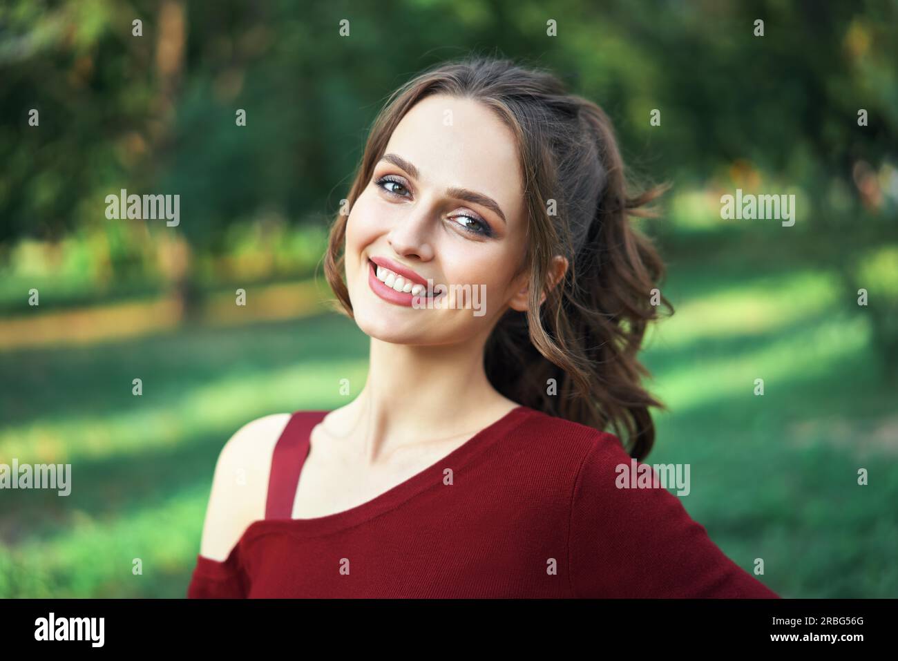 Portrait de la jeune belle femme à l'extérieur sur fond vert de la nature estivale. Concept de beauté féminine Banque D'Images