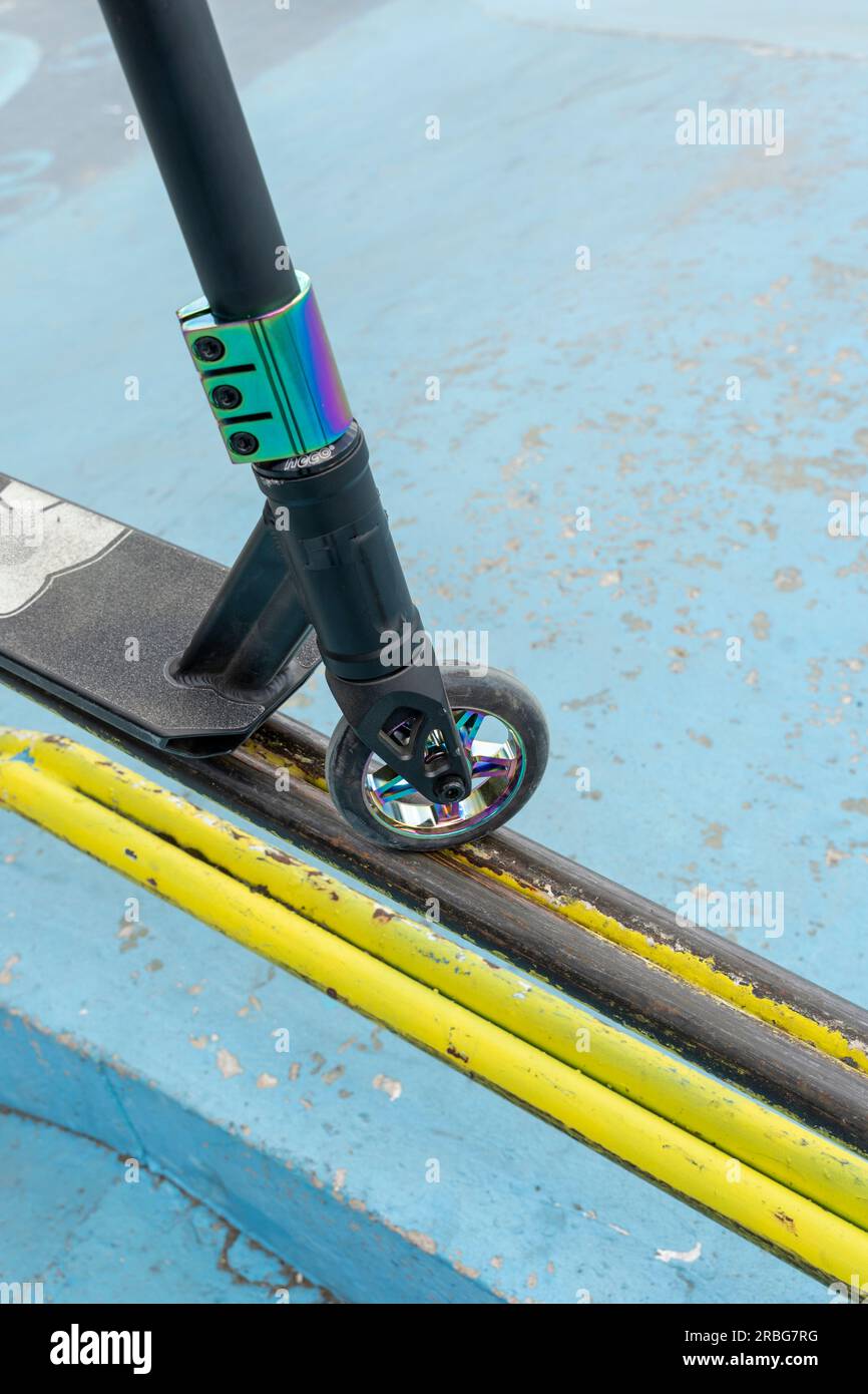 Stunt scooter sur la rampe de tube de fer jaune du skate Park. Sauts et astuces. Sports de plein air urbains extrêmes, concept de mode de vie sain. loisirs sportifs Banque D'Images