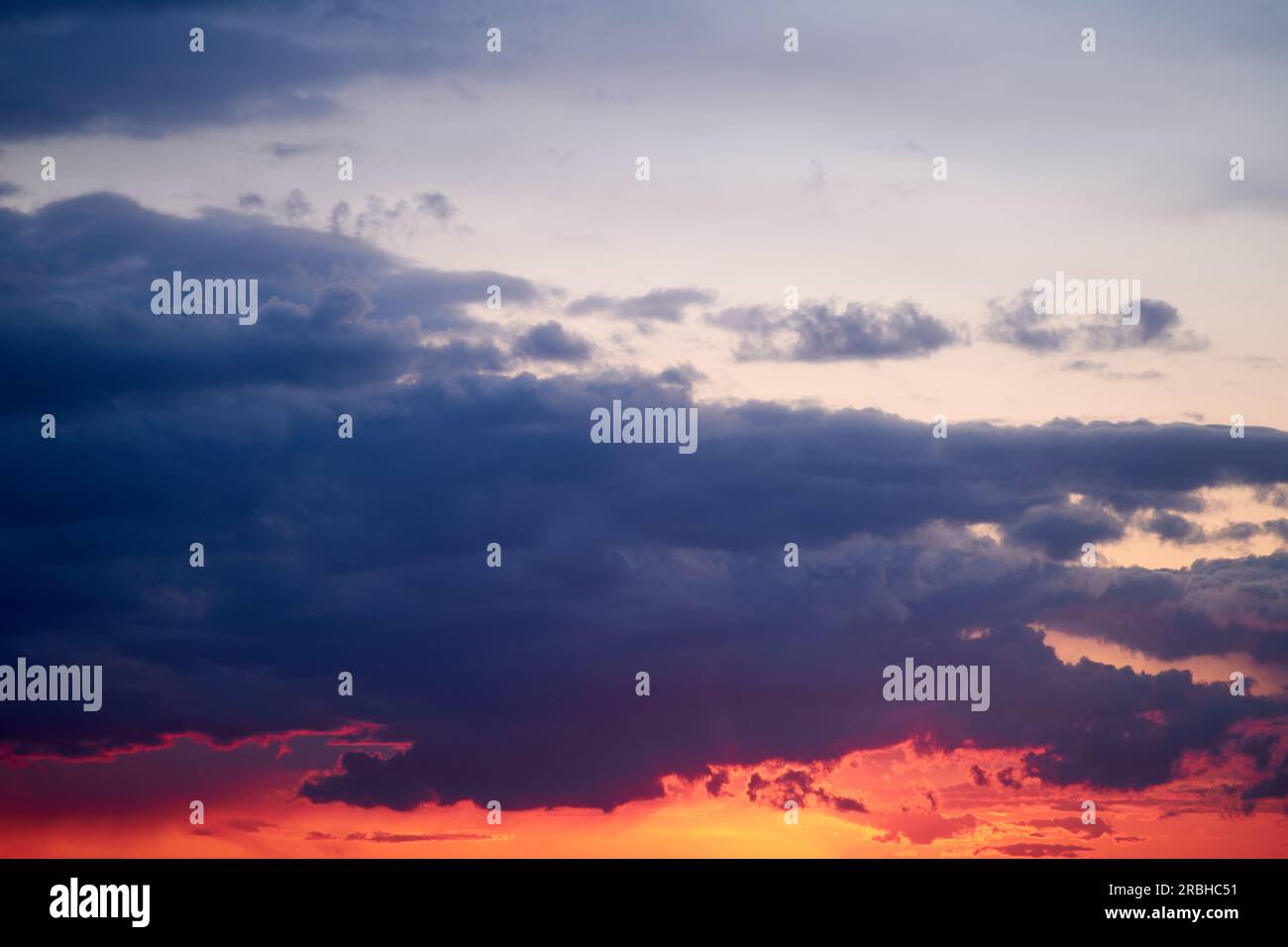 Le ciel du soir était une toile d'oranges et de rouges, reflétant la lumière qui s'estompe. Banque D'Images