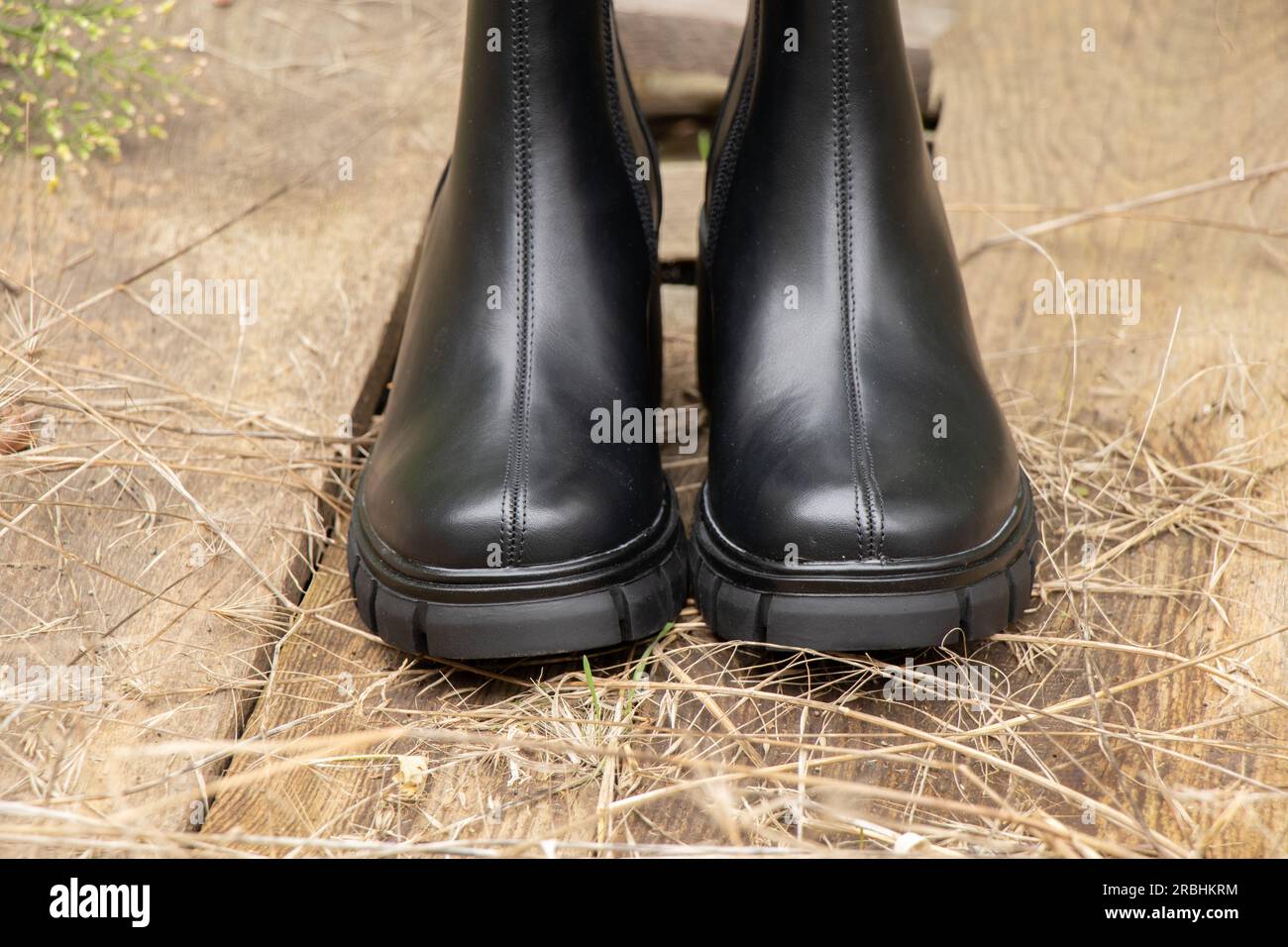 black high boots pour femmes avec des semelles épaisses se tiennent sur la vieille planche dans la rue, les chaussures d'hiver pour femmes, les chaussures Banque D'Images