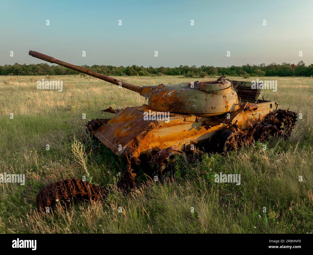 Détruit rouillé, abandonné et brûlé le char de combat dans les champs verts au coucher du soleil. Vous pouvez utiliser cette image comme illustration par exemple guerre Banque D'Images