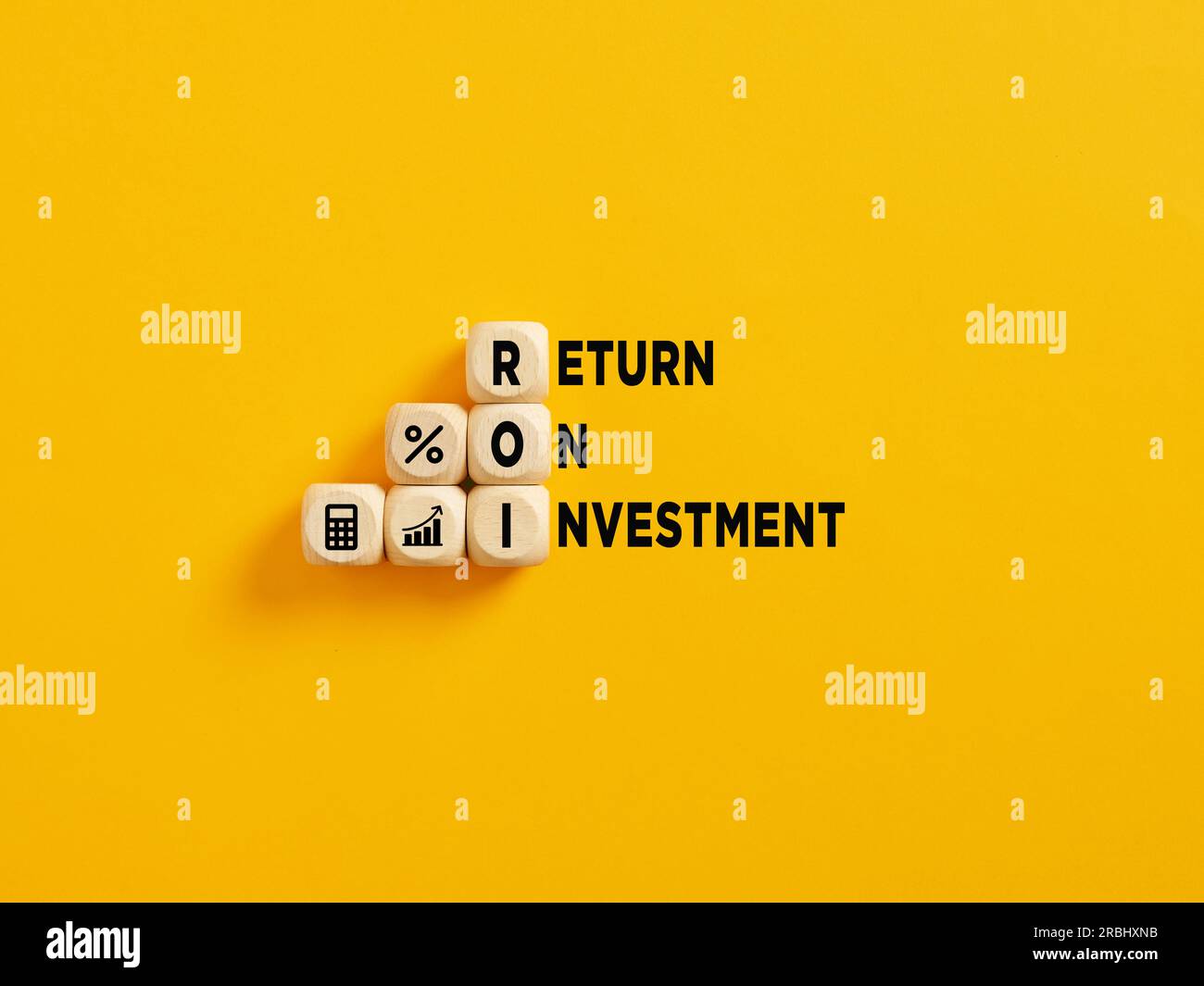 L'acronyme ROI et Return on Investment texte sur cubes en bois sur fond jaune. Banque D'Images