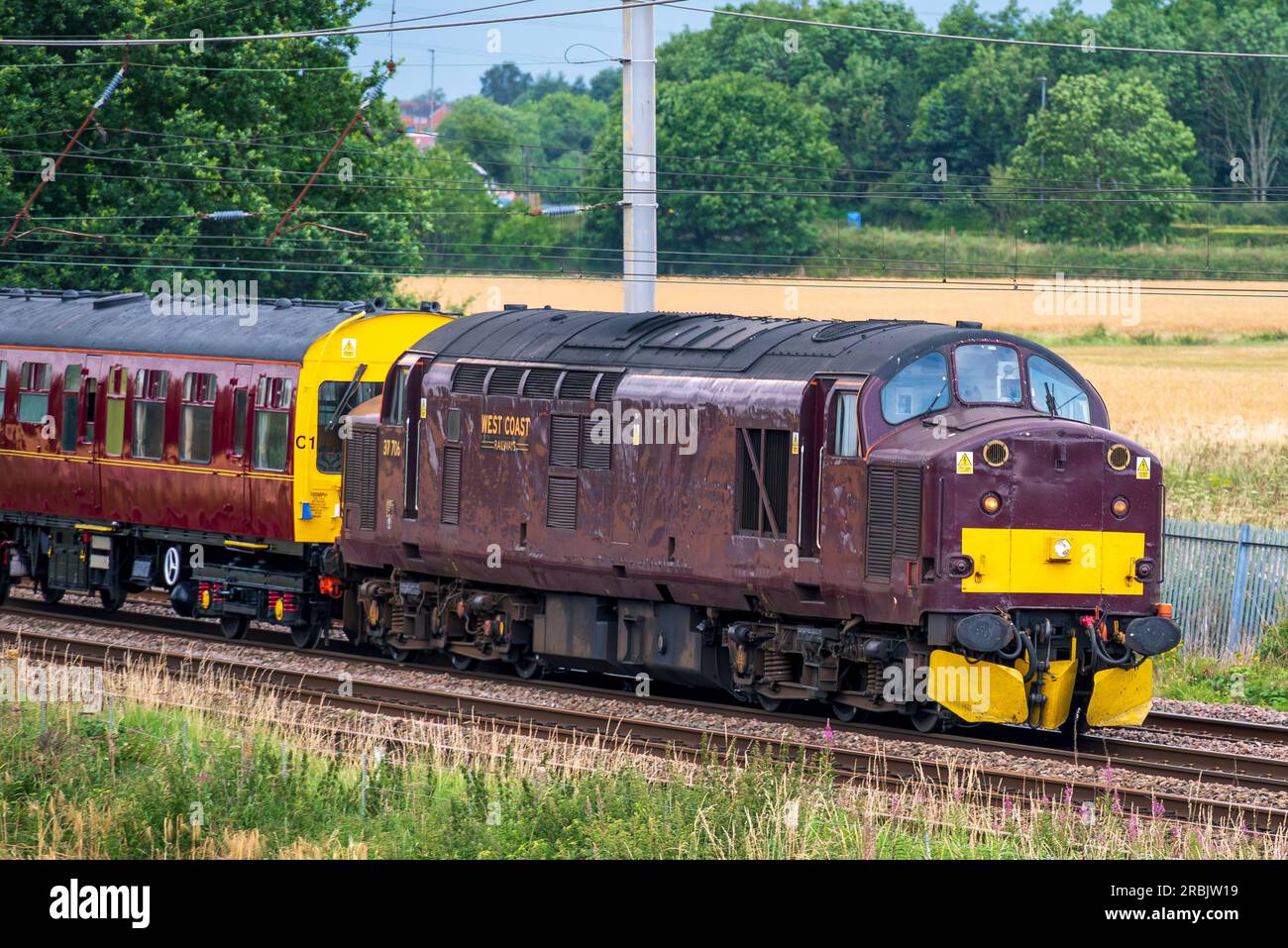 Chemins de fer de la côte Ouest classe 37 diesel 37706 passant par Winwick sur la ligne principale de la côte Ouest en direction du sud. Banque D'Images