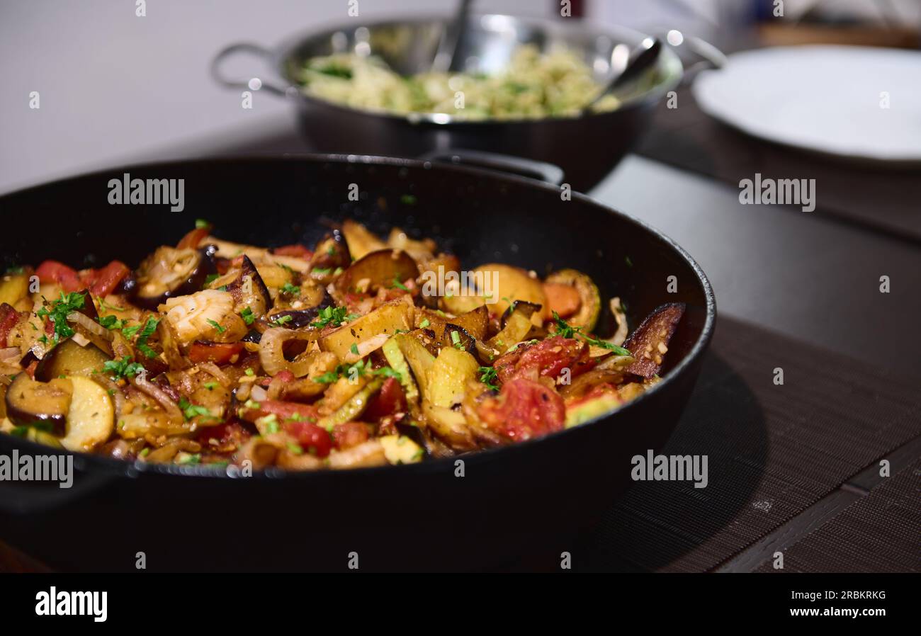 Concept de nourriture végétalienne saine. Ragoût de légumes de saison bio, ragoût, gratin, ratatouille française dans une poêle en fonte sur une table de cuisine en bois. Sain d Banque D'Images