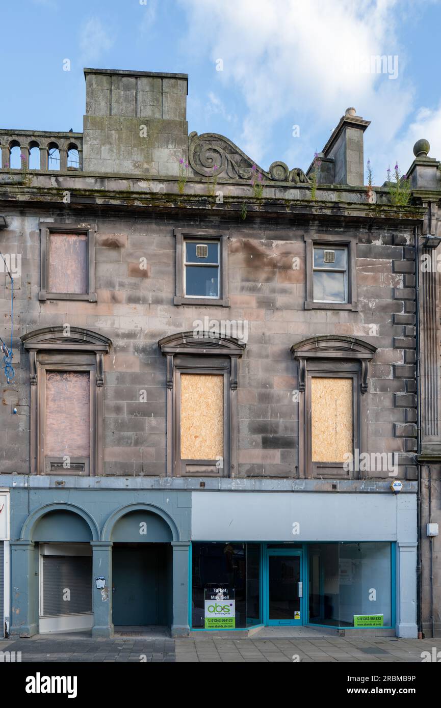 9 juillet 2023.High Street, Elgin, Moray, Écosse. Ceci est un bâtiment de trois étages sur Elgin High Street qui est vacan, fenêtres à barreaux et mauvaises herbes poussant fr Banque D'Images