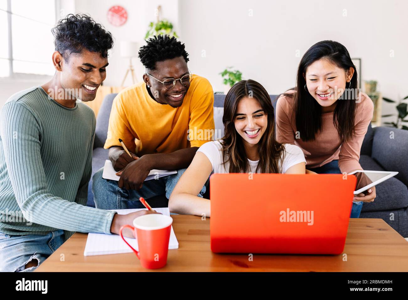 Jeune groupe d'amis étudiants qui étudient ensemble avec l'ordinateur à la maison Banque D'Images