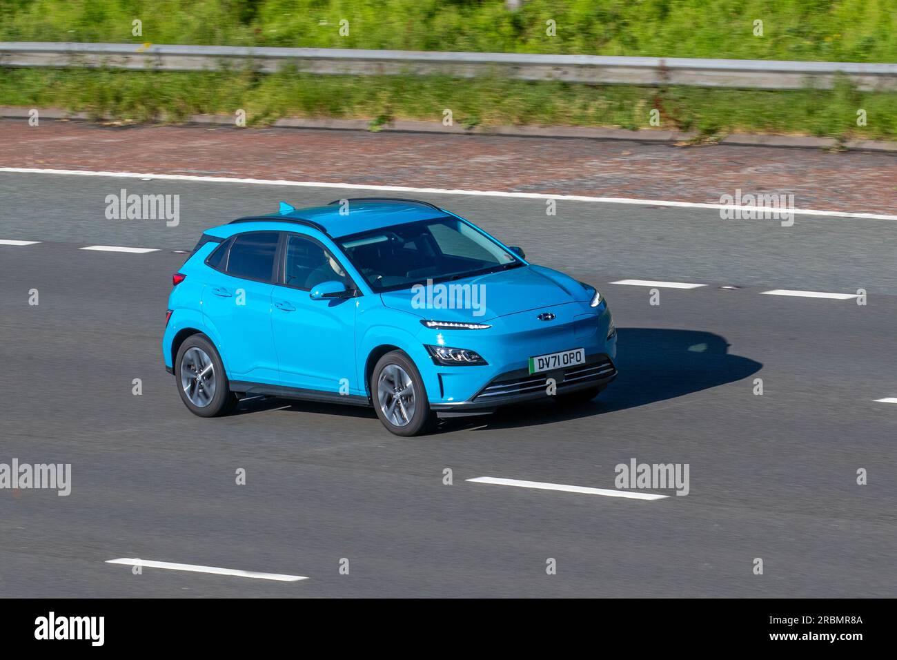 2022 Bleu Hyundai Kona Premium EV, 204 PMSM 64KWH voiture Hatchback Electricité 150 kW se déplaçant à grande vitesse sur l'autoroute M6 dans le Grand Manchester, Royaume-Uni Banque D'Images