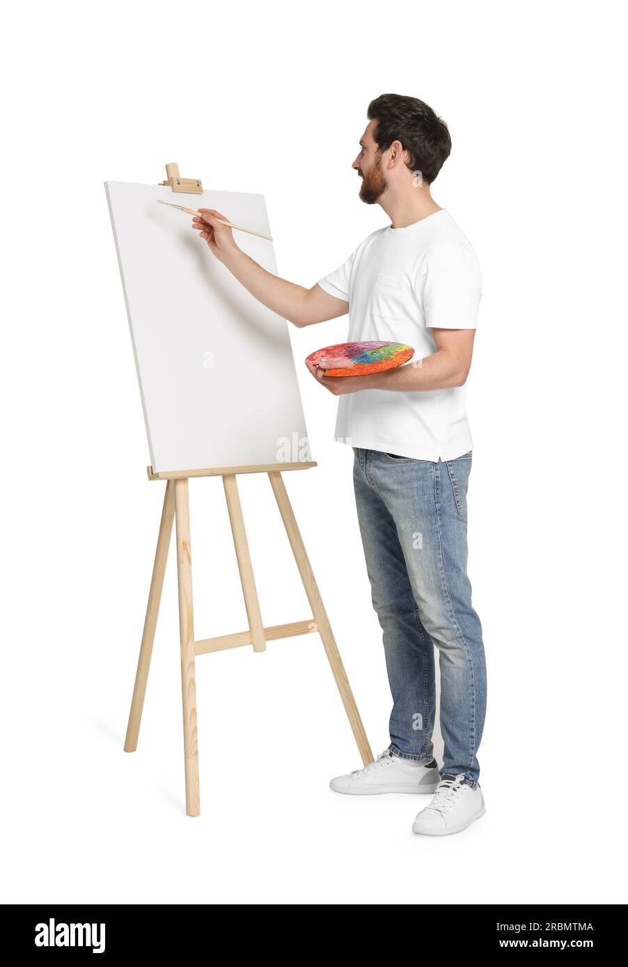 Homme avec peinture au pinceau sur fond blanc. Utilisation du chevalet pour tenir la toile Banque D'Images