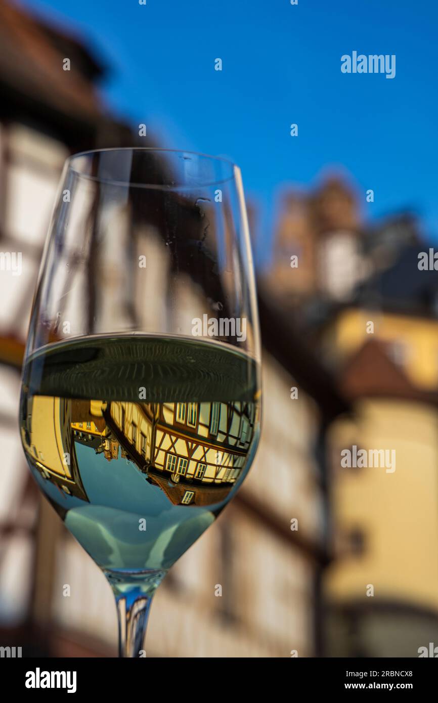 Les bâtiments à colombages et les tours de la vieille ville se reflètent dans un verre rempli de vin blanc, Wertheim, Spessart-Mainland, Franconie, Baden-Wuer Banque D'Images