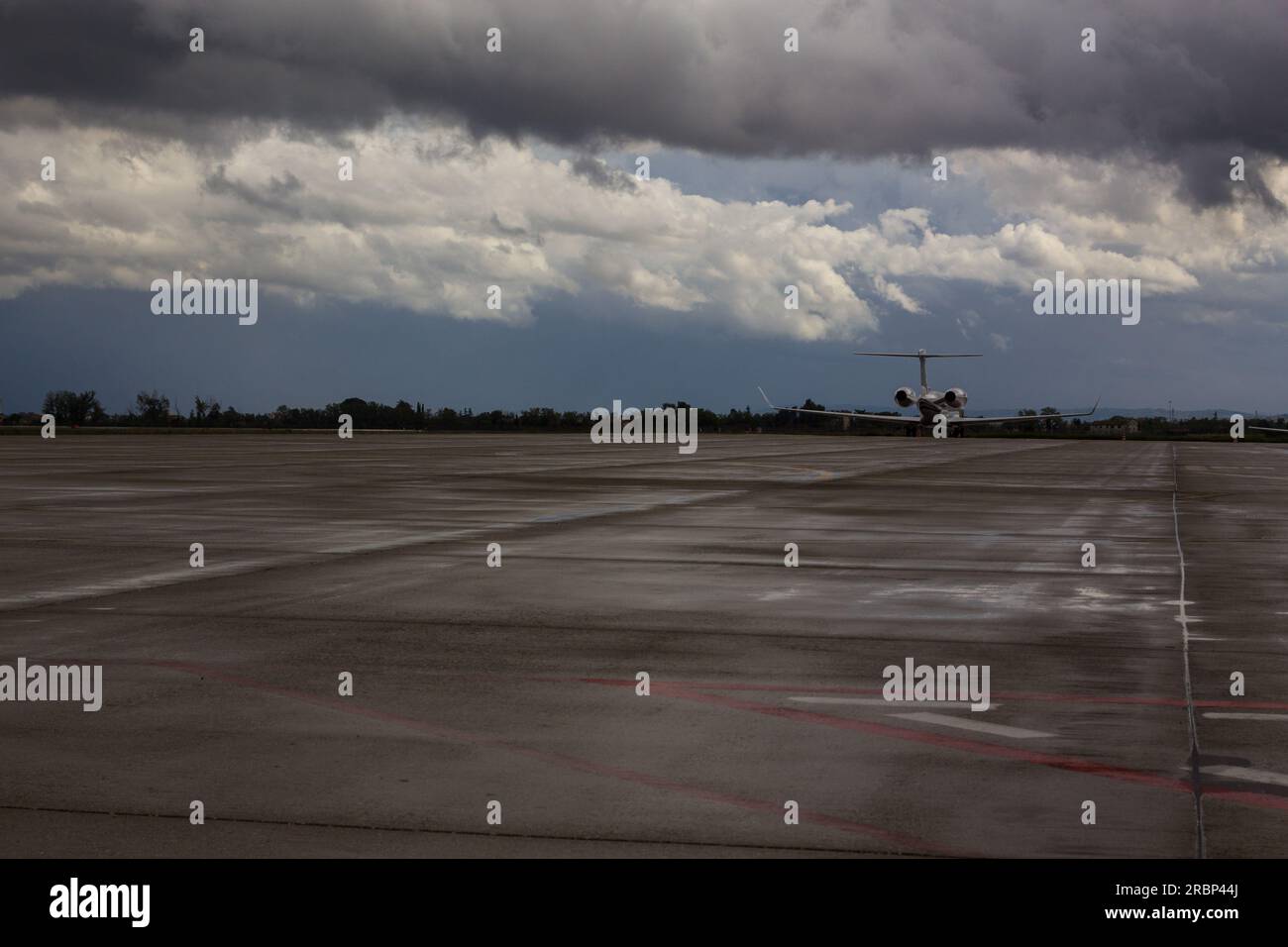 Un jet privé sur une piste d'aéroport sous un ciel nuageux Banque D'Images