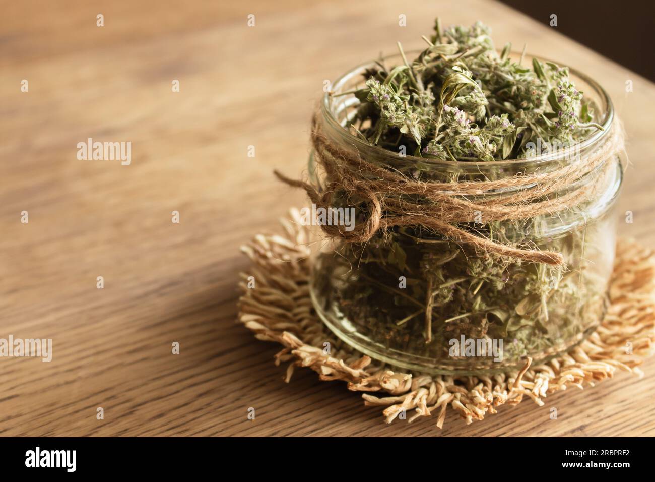 Thym séché dans un bocal en verre sur fond en bois. Tisane en pot. Concept de produits ECO. Nourriture saine. Tisane maison. Séchez le thym avec des fleurs. Banque D'Images