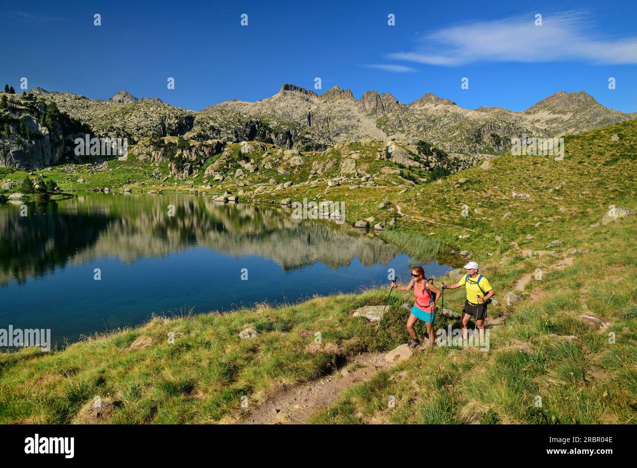 Homme et femme passe de randonnée Estanh Plan lac de montagne, Circ de Colomers, Aigüestortes i Estany de Sant Maurici Parc National, Catalogne, Pyrénées, Espagne Banque D'Images