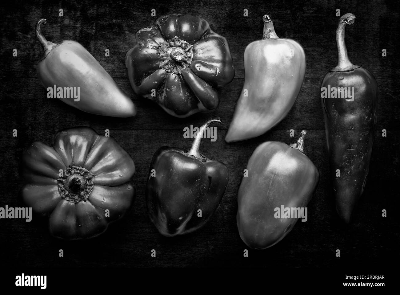 Un groupe de poivrons naturels du jardin sur un fond sombre Banque D'Images