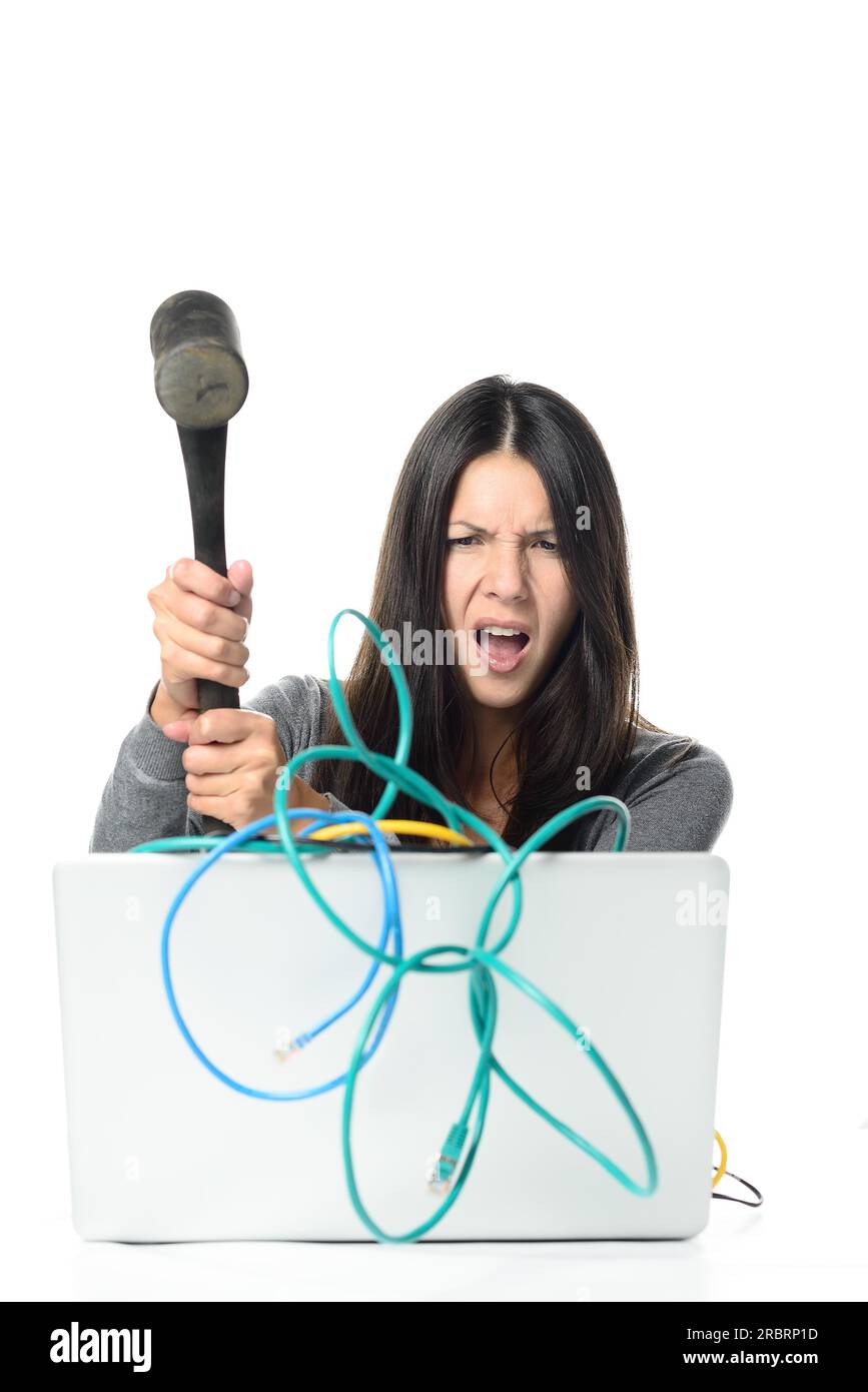 Angry Woman Smashing son ordinateur portable avec des câbles réseau emmêlés à l'aide de Grand marteau. Isolé sur fond blanc Banque D'Images