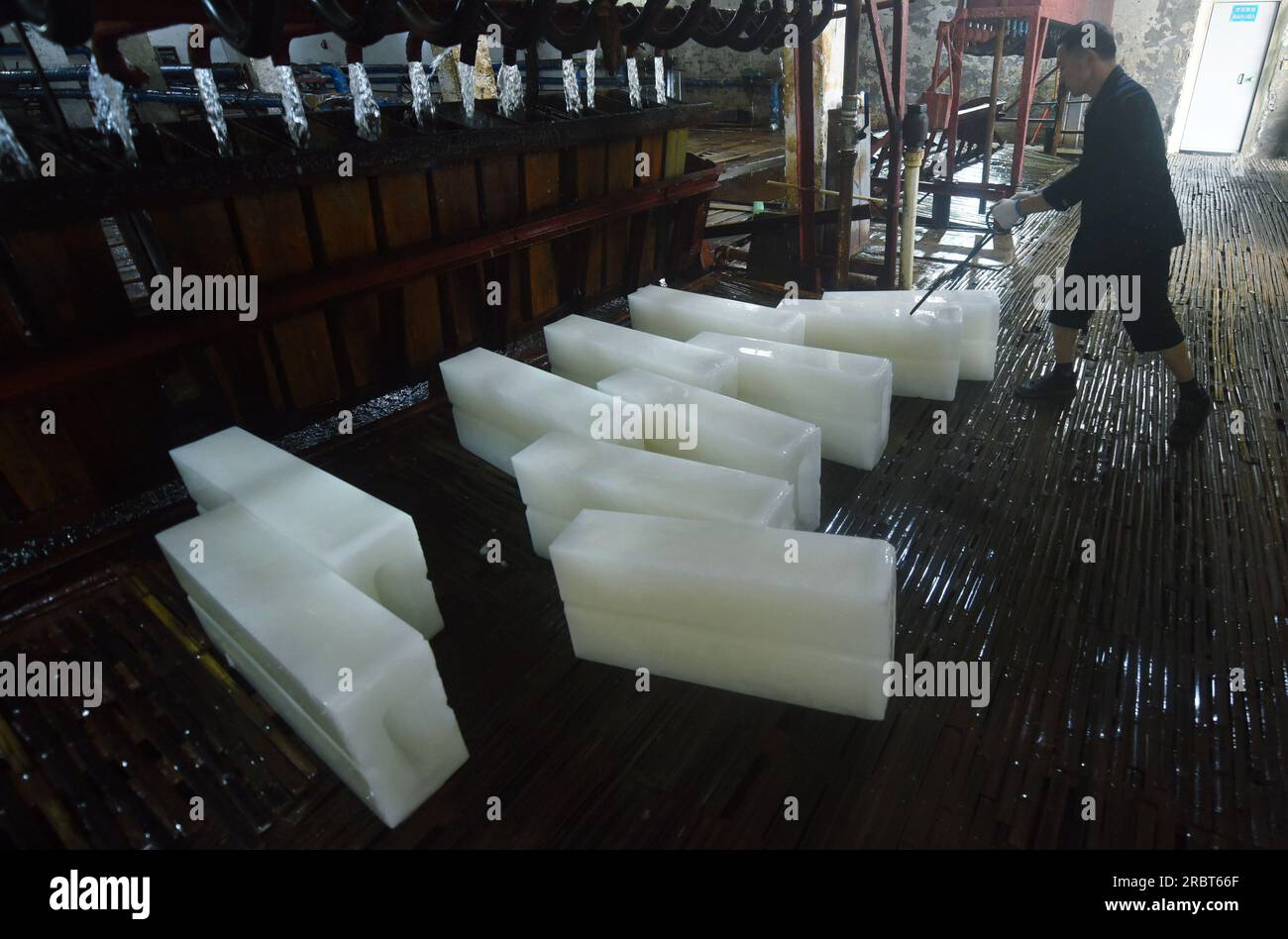 HANGZHOU, CHINE - 11 JUILLET 2023 - Un ouvrier transporte des glaçons fraîchement préparés dans une usine de glace à Hangzhou, province du Zhejiang, Chine, le 11 juillet 2023. Attendez Banque D'Images